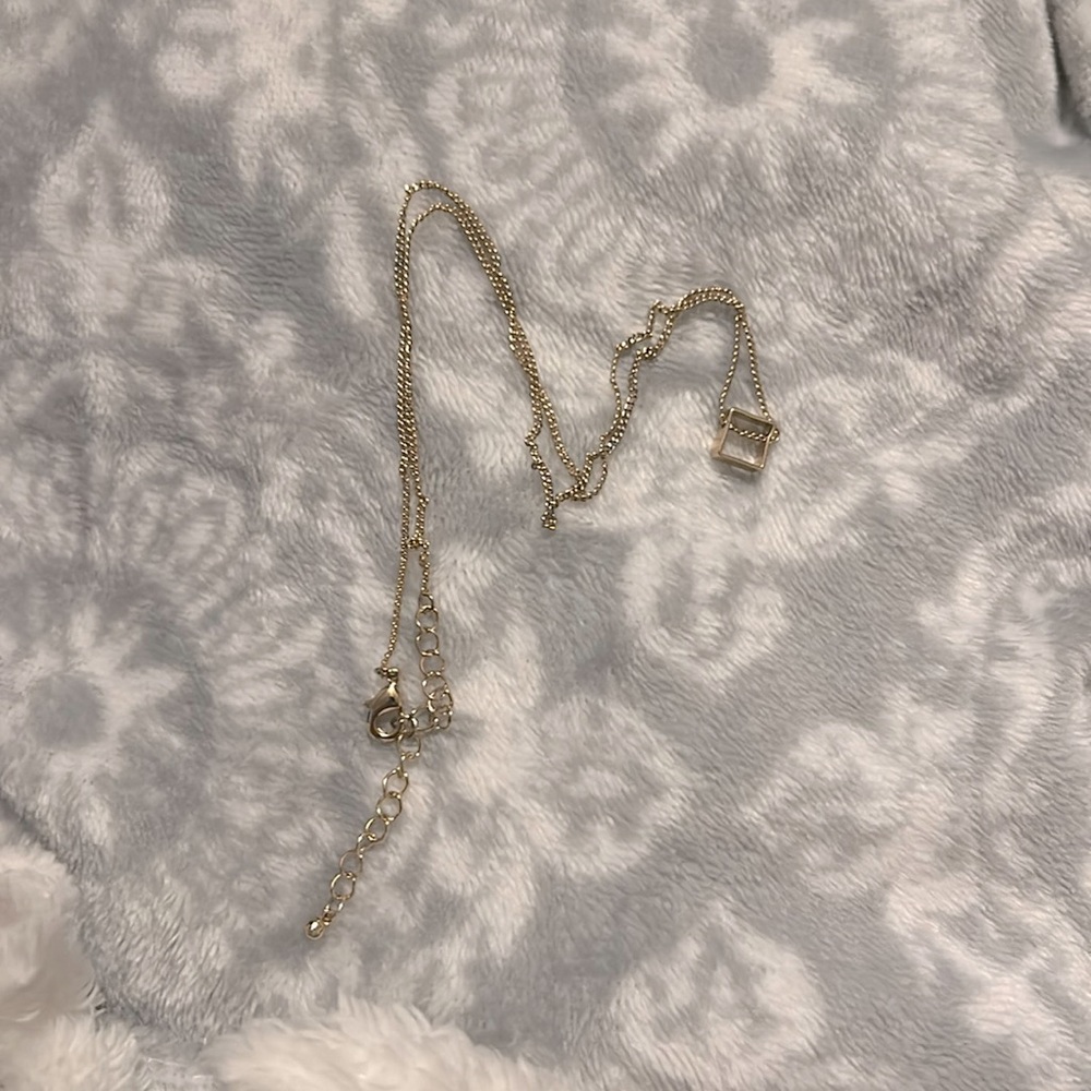 This is a gold necklace with a square charm!